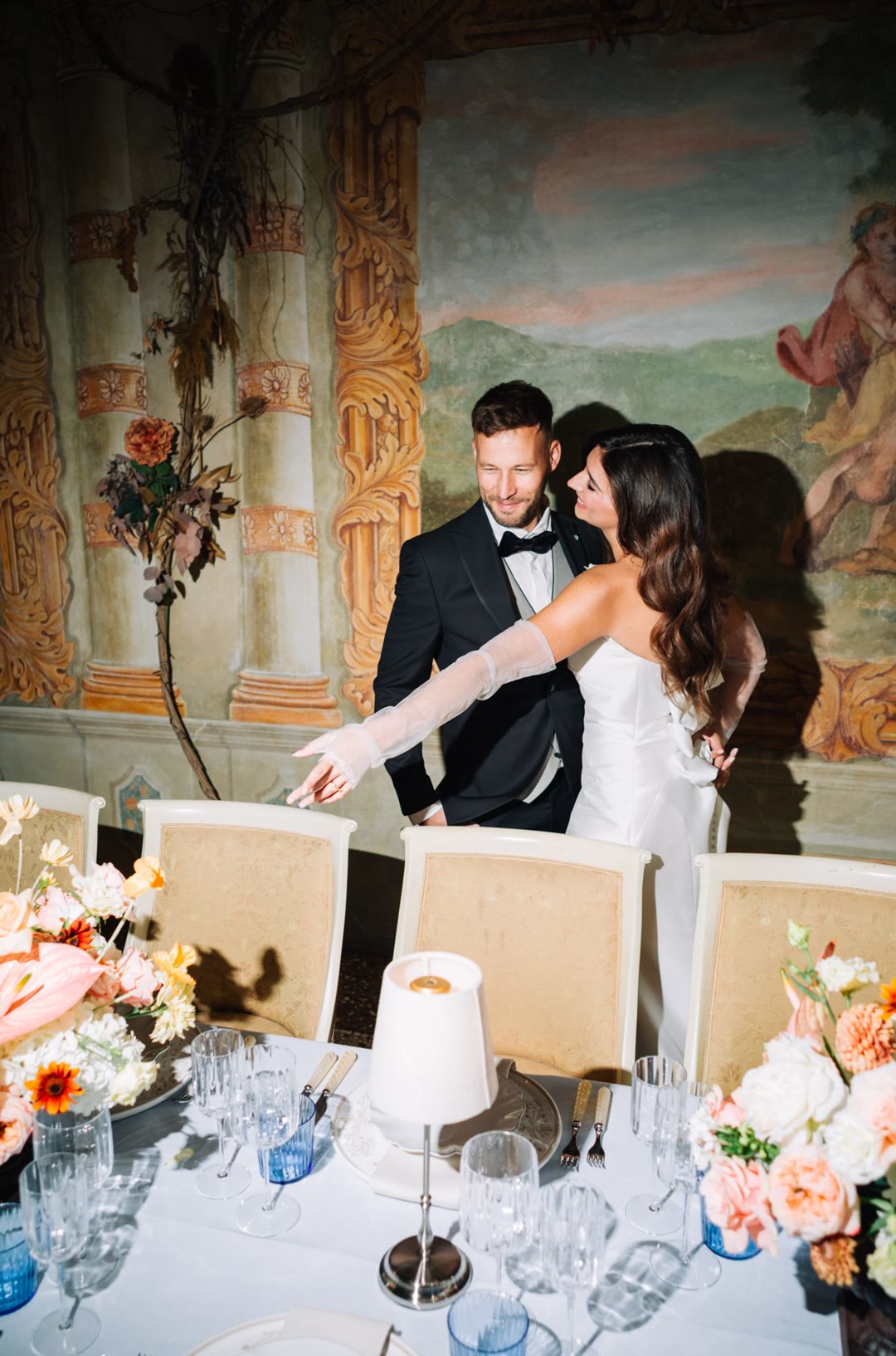 Freskierter Saal mit gedecktem Tisch und Blumen in der Villa Marcello Marinelli.